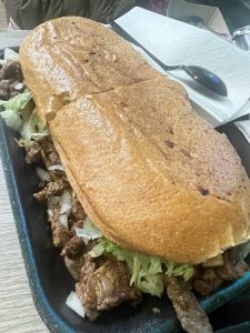 Carne Asada Torta with grilled meat, lettuce, tomatoes, and avocado at La Lomita Mexican Grill. Feel free to adjust any details as needed!